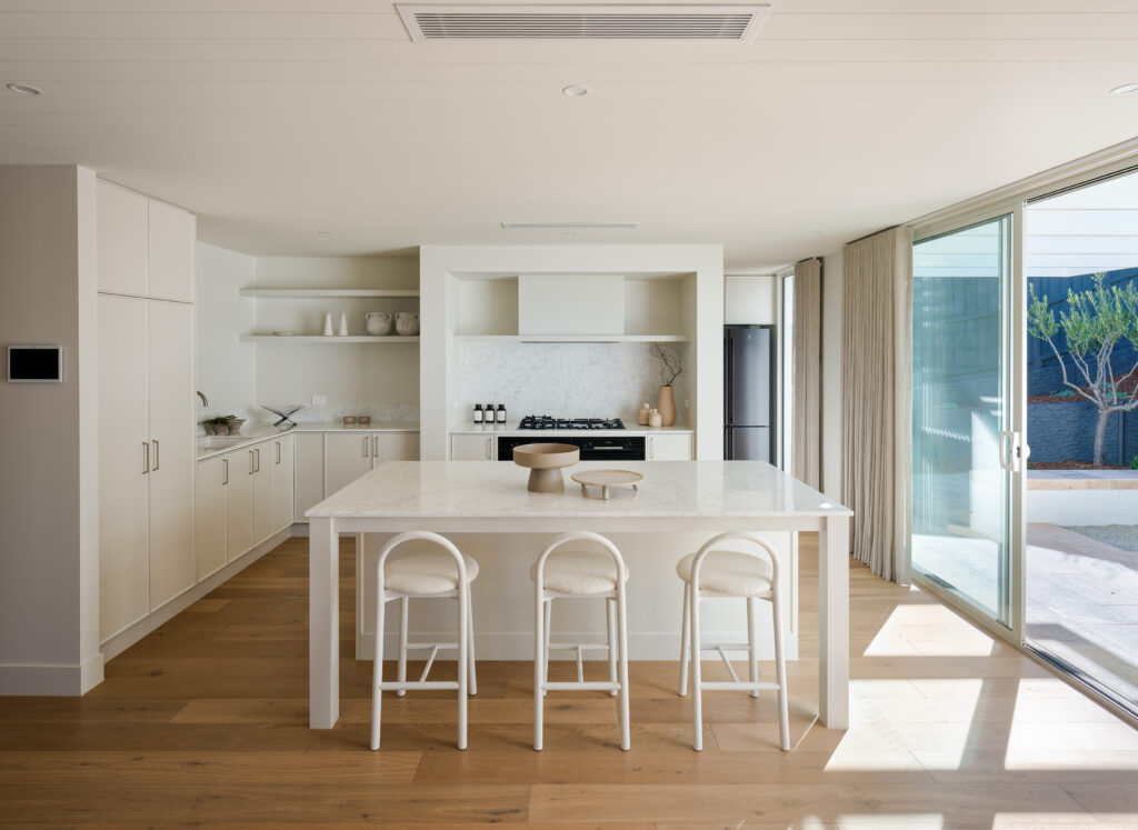 Contemporary L-shaped kitchen layout featuring Caesarstone Mineral<sup>™</sup> Surface island, seamless cabinetry and generous workspace for social cooking.