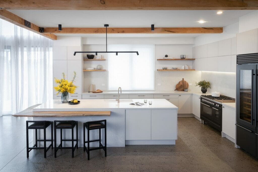 Family-style kitchen with white benchtops and cabinetry, black modern appliances