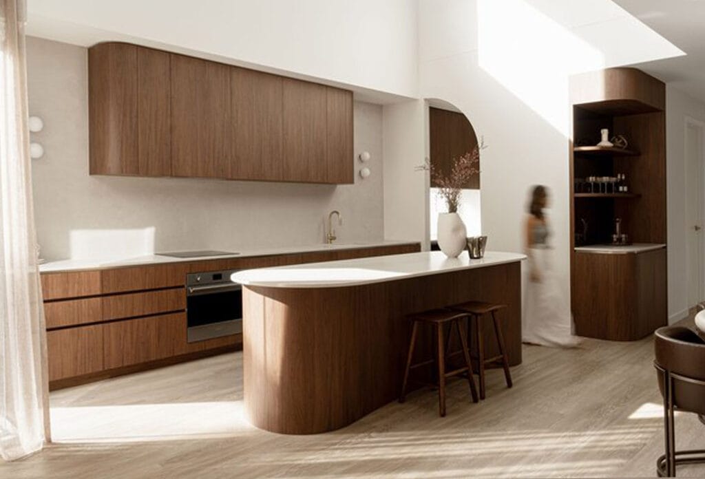 Kitchen design featuring island benchtop with Caesarstone Mineral Surface Adamina and wallnut wood cabinetry