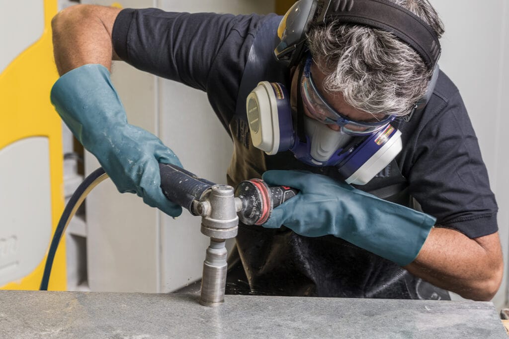 Stonemasons in safety gear, carefully handling Caesarstone slab