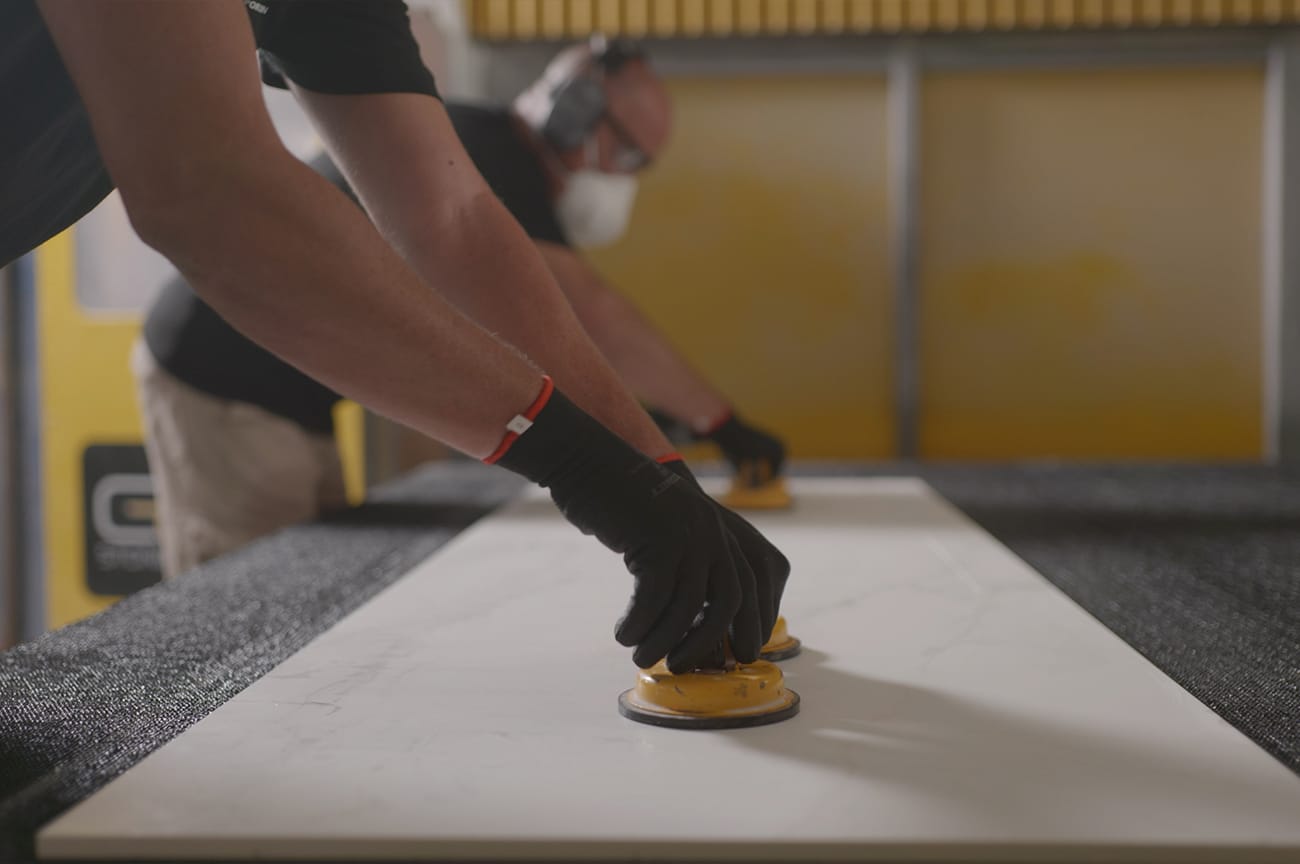 Stonemasons in safety gear, carefully handling Caesarstone slab