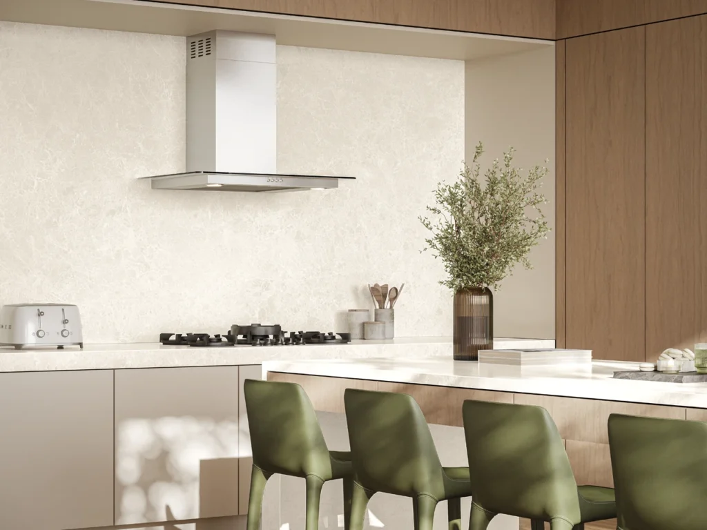 Minimalist kitchen with white splashback and benchtops, and green dining room chairs