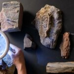 Closely inspecting the elements of natural stones with a handheld light to draw inspiration Caption: Drawing inspiration from natural stones and ceramics