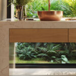 Pairing benchtop with natural textures including timber cabinetry, rattan details, and warm metallic finishes.
