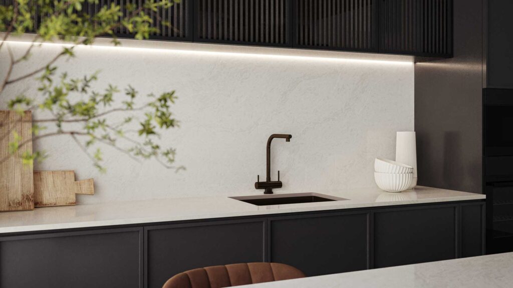Kitchenette featuring Caesarstone countertops, fluted timber cabinetry, and a light-reflective minimalist palette.