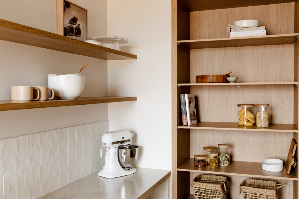 Butler’s pantry, open oak shelving, and natural woven baskets for warm, functional storage.