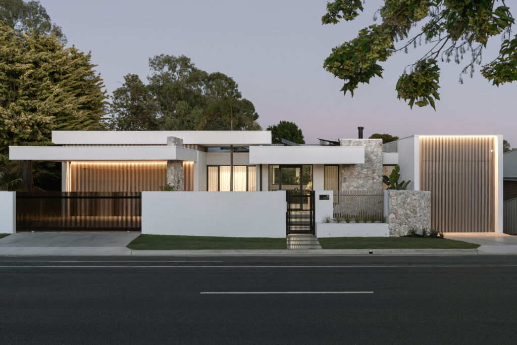 Front façade of modern home with stone accents, timber screening, and minimalist architecture.