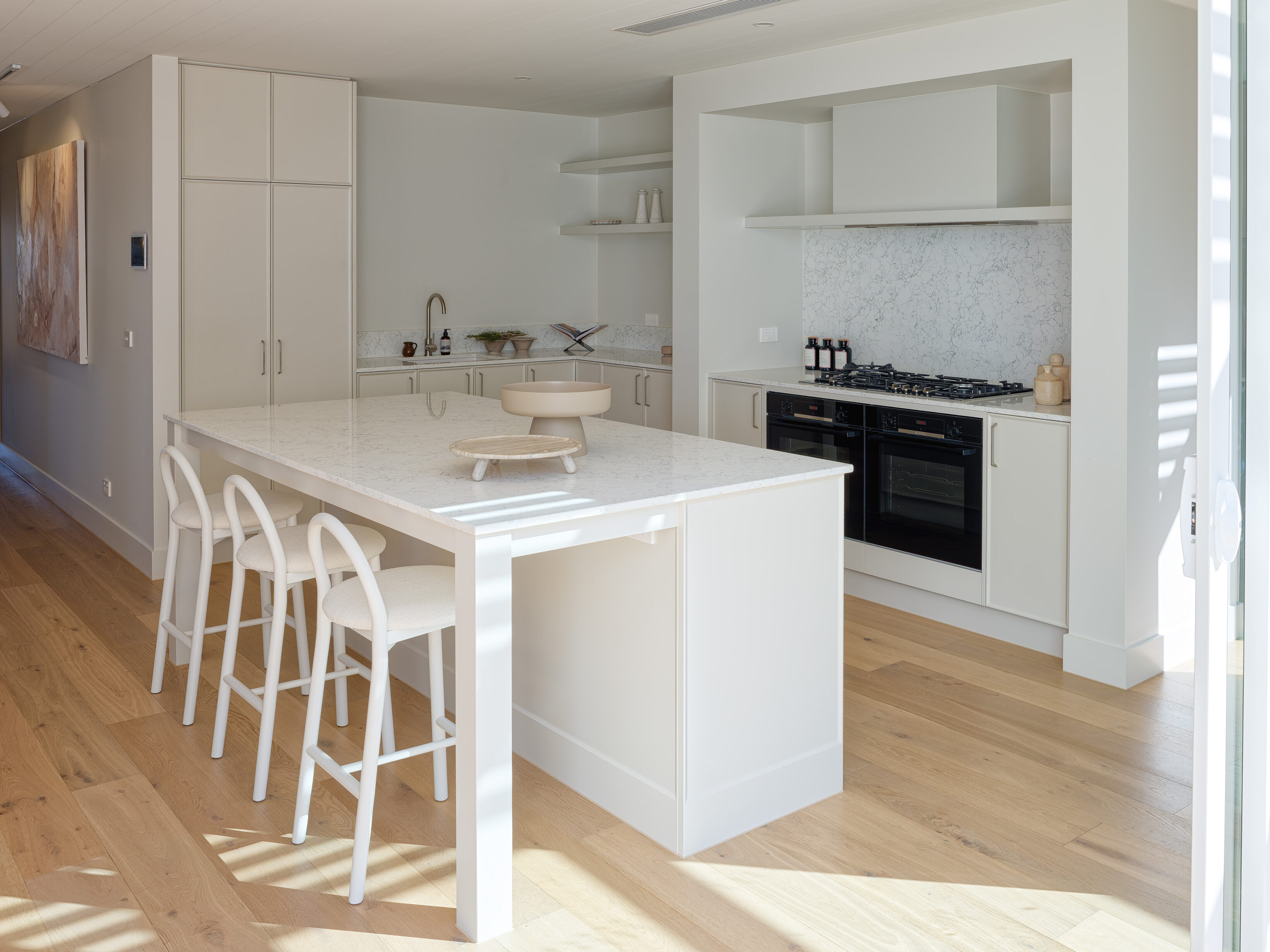 Kitchen cooking zone with Caesarstone Arabetto™ benchtop, open shelving, and soft neutral joinery
