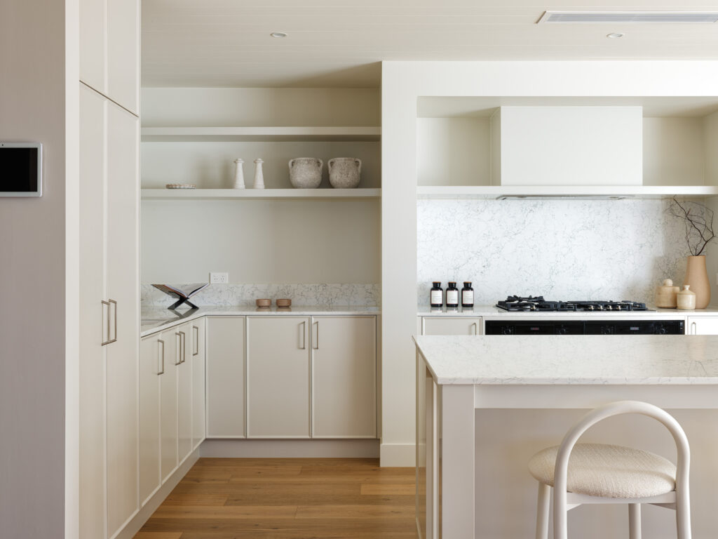 Kitchen cooking zone with Caesarstone Arabetto™ benchtop, open shelving, and soft neutral joinery