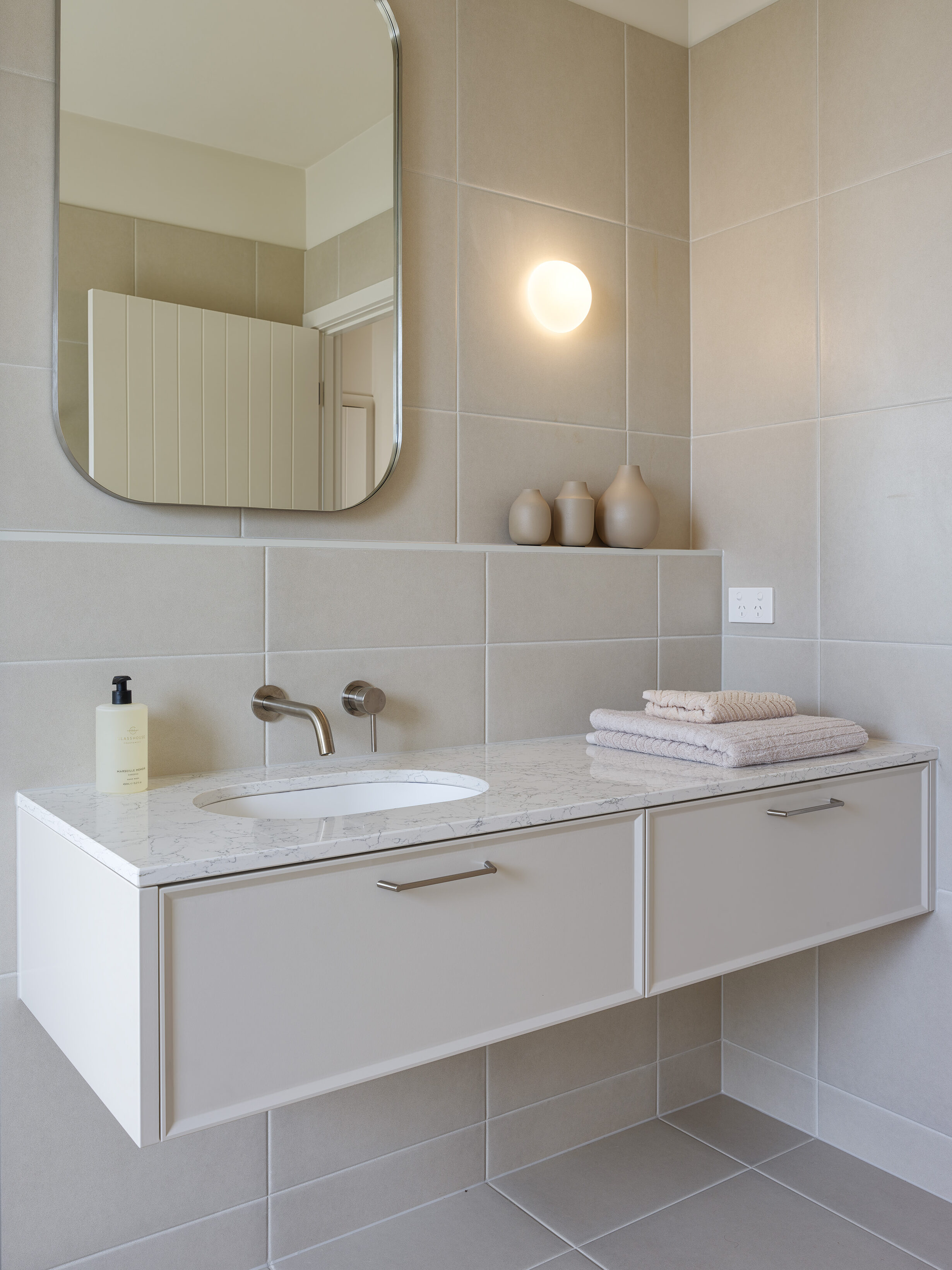 Bathroom vanity featuring Caesarstone Arabetto™ mineral surface, neutral cabinetry, and soft natural light