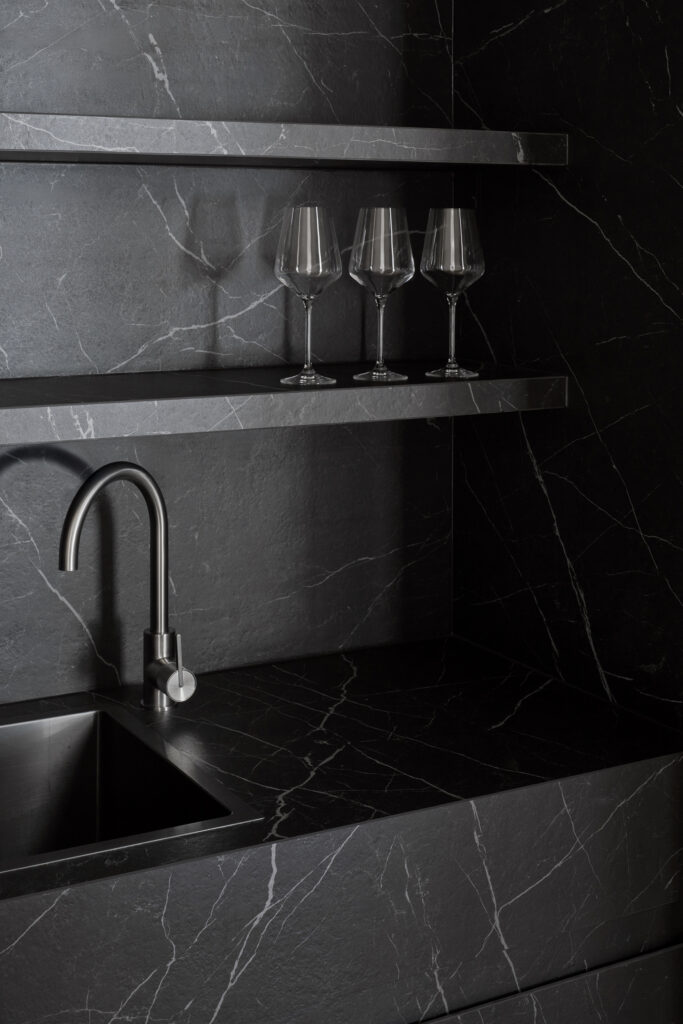 Bar installation inside Caesarstone’s Wingfield flagship showroom in Adelaide featuring Smokestone surface with integrated shelving and sink.