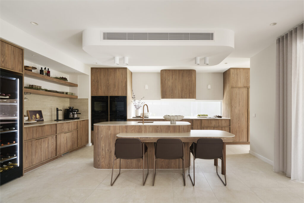 Open-plan kitchen and dining space with Silvax Porcelain benchtops, timber joinery and natural light at The Kingscliff, VIC