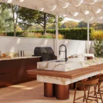 Caesarstone porcelain 536 Antikella in Modern outdoor kitchen with marble-top island, wooden stools, built-in grill, and lush greenery.