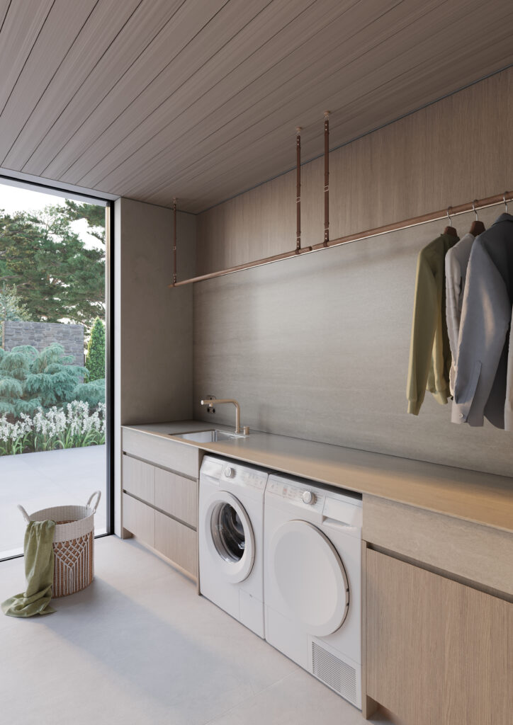 Minimal laundry room featuring Caesarstone<sup>®</sup> 550 Silvax porcelain benchtops and splashback paired with light timber cabinetry and soft earthy finishes.