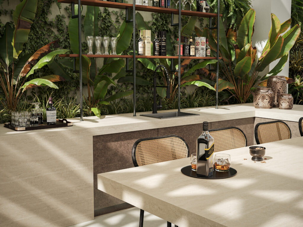 Outdoor entertaining space featuring Caesarstone<sup>®</sup> 550 Silvax porcelain benchtops with travertine-inspired detailing surrounded by lush tropical landscaping.