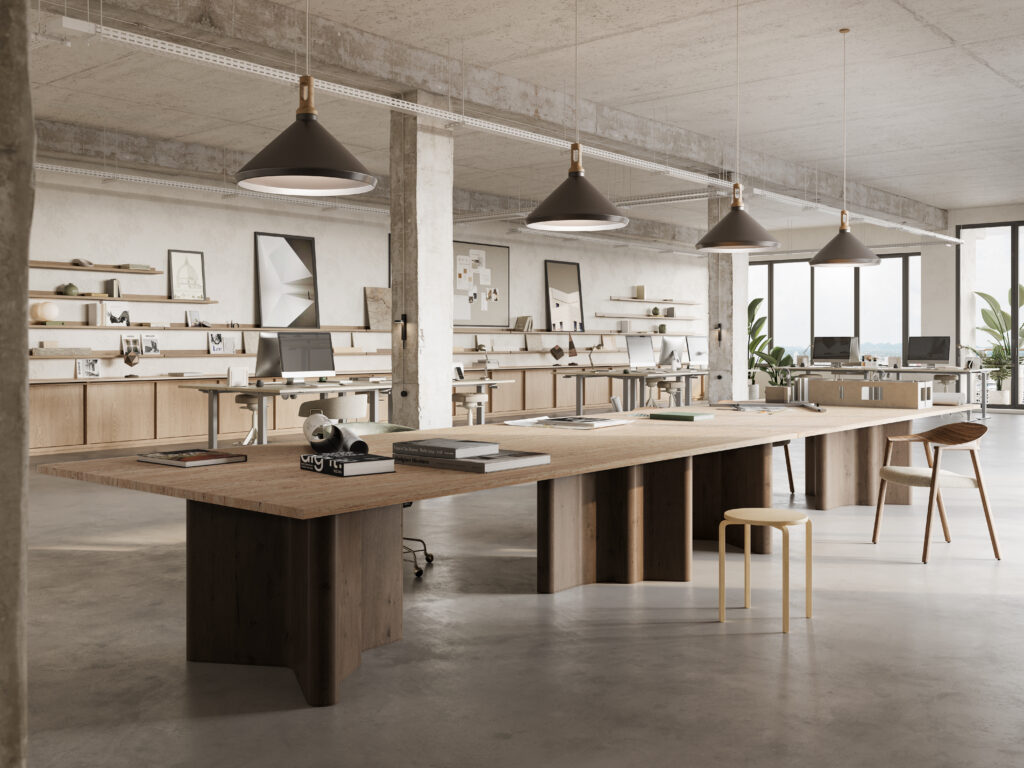 Industrial-style creative workspace featuring large-format Caesarstone<sup>®</sup> 551 Travina porcelain tabletops with warm layered stone-inspired detailing.