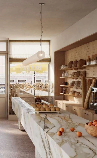 Caesarstone<sup>®</sup> Antikella™ 536 porcelain island benchtop in warm artisan bakery interior with timber shelving and natural light