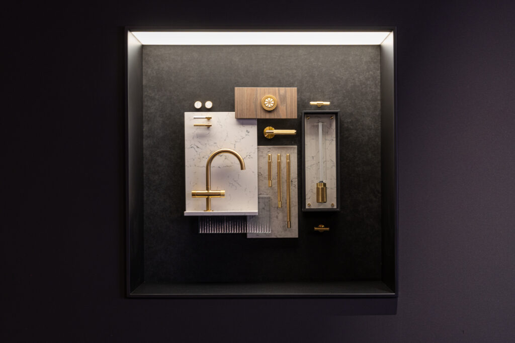 Curated material display combining Caesarstone<sup>®</sup> surfaces with GROHE SPA components, illustrating the layered design language of the installation.