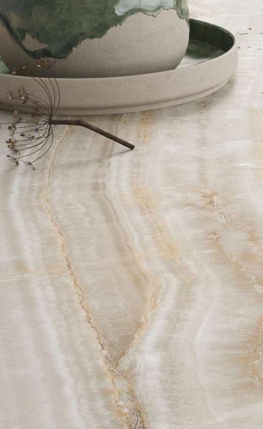 Caesarstone<sup>®</sup> Onyxa™ 509 porcelain surface detail showing wavy translucent veining and golden rust deposits with Luster Effect finish