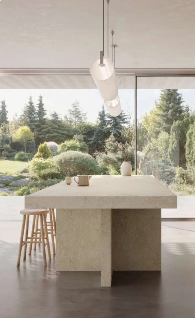 Caesarstone<sup>®</sup> Sedara™ 8252 ICON Mineral kitchen island benchtop in light-filled open plan space with garden outlook and timber stools