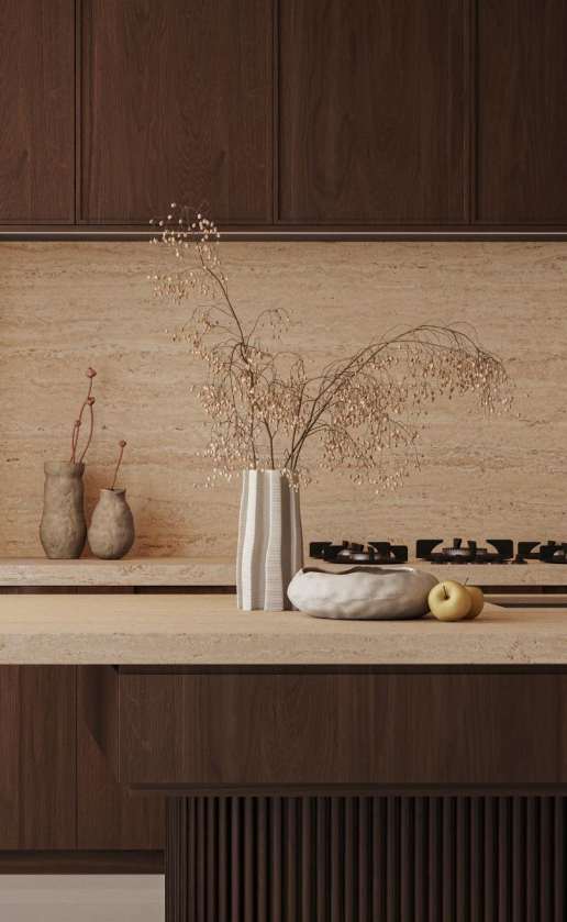 Caesarstone<sup>®</sup> Travina™ 551 porcelain benchtop and splashback in warm kitchen with dark cabinetry, gas cooktop and dried botanical styling