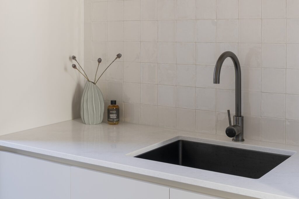 Laundry with Glacier Flow™ benchtop and integrated cabinetry