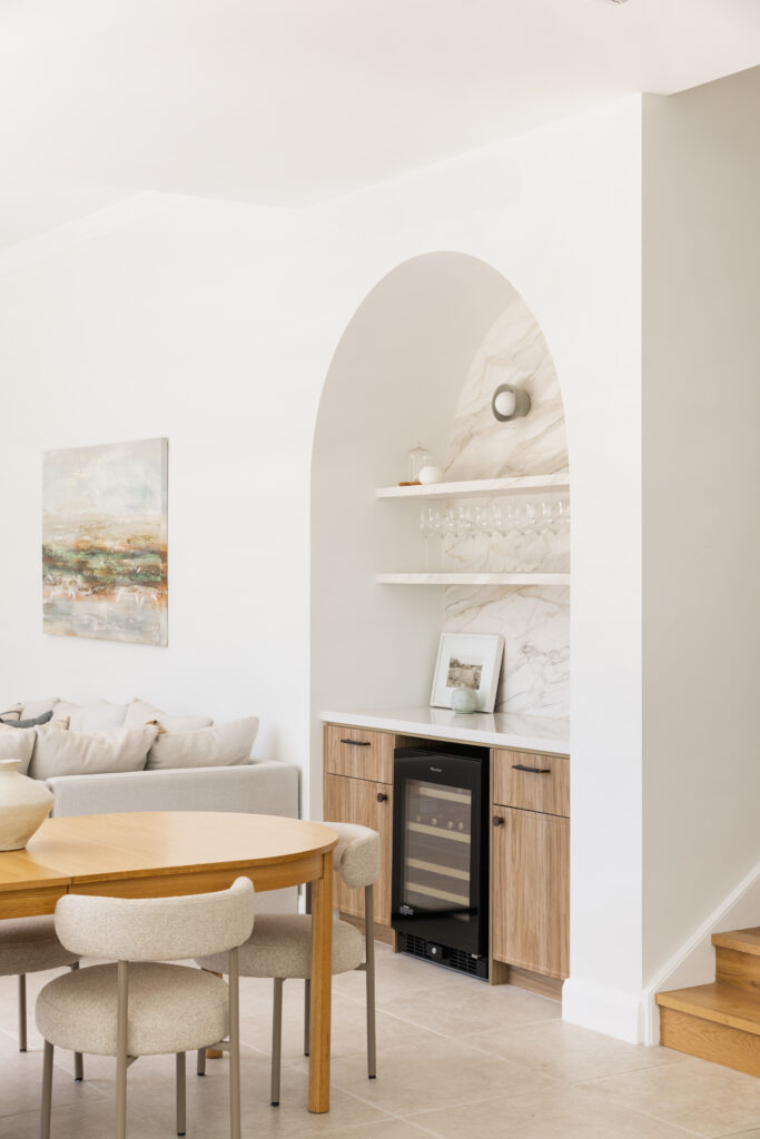 Arched bar niche with Mirabel™ porcelain splashback, floating shelves, wine fridge and fluted timber cabinetry in Seaforth home