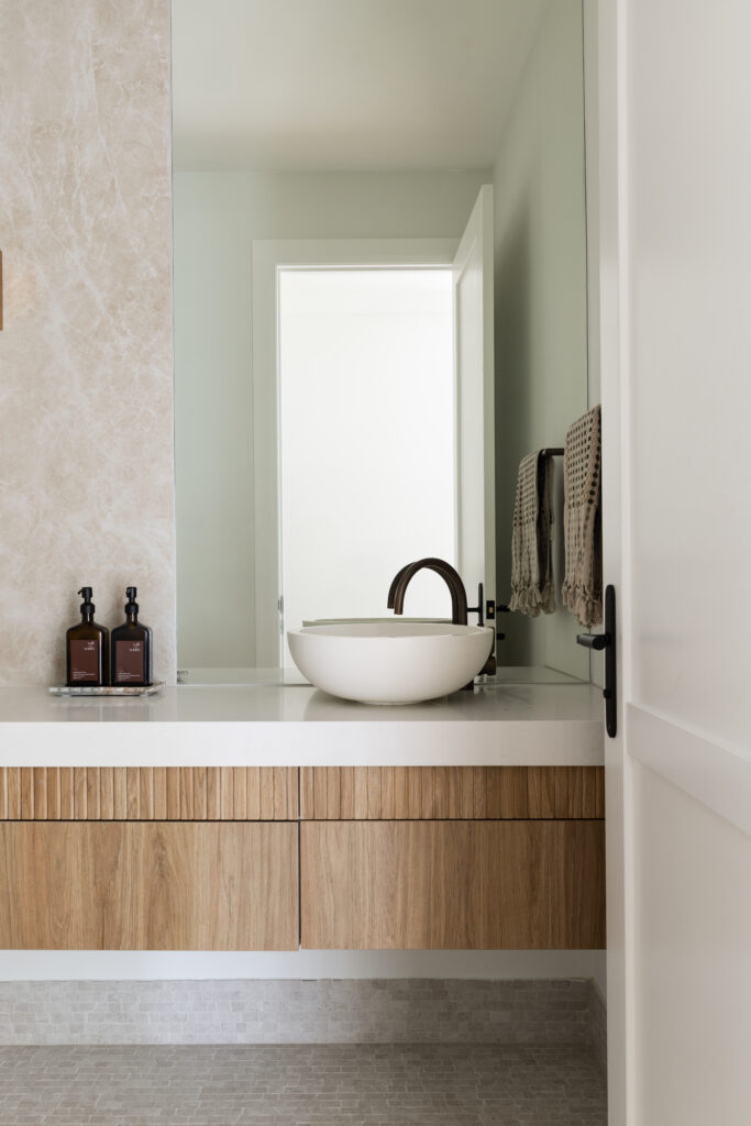 Bathroom vanity featuring Organic White™ benchtop, white basin, matte black tapware and floating timber cabinetry in Seaforth home