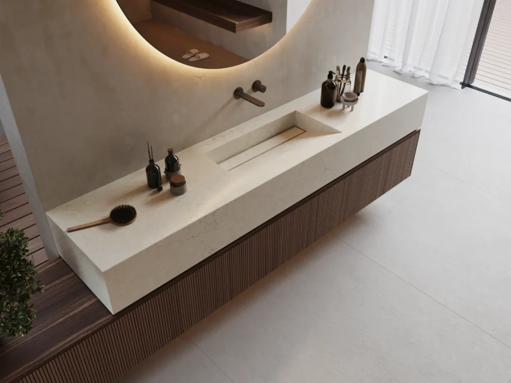 Caesarstone<sup>®</sup> floating vanity benchtop with an integrated trough sink, warm timber cabinetry and a curved backlit mirror in a contemporary ensuite