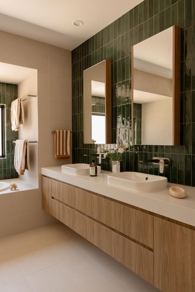 Green vertical kit-kat wall tiles paired with a Caesarstone<sup>®</sup> Fresh Concrete vanity top and floating timber drawers by Broadrick.