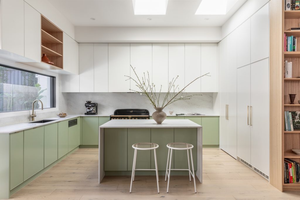 Sage green kitchen cabinetry paired with Caesarstone<sup>®</sup> Lunar Frost benchtop and splashback in a modern Australian home designed by Level Built.