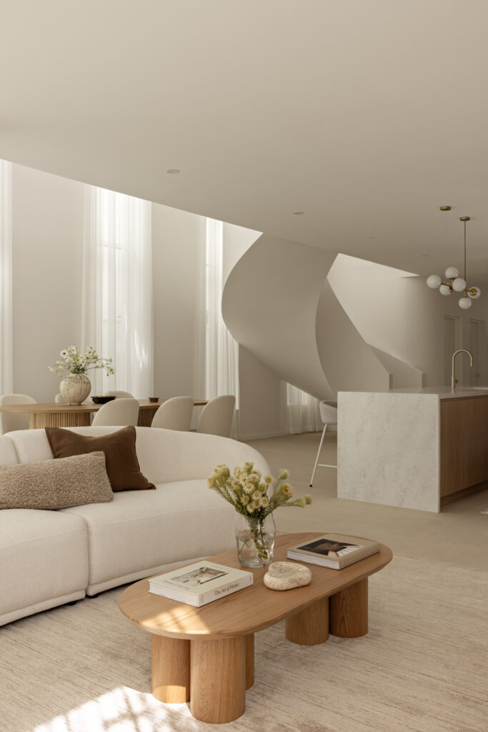 Open-plan living, dining and kitchen space at Project Mars with curved staircase and Caesarstone Lunar Frost island.