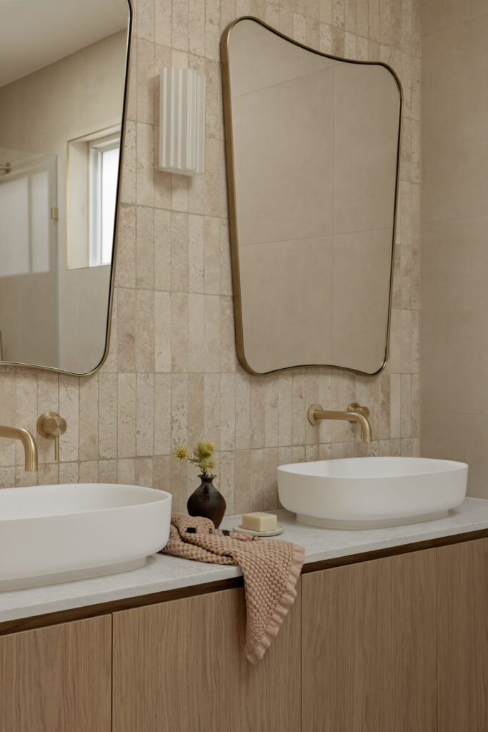 Close view of Caesarstone Lunar Frost double vanity with brass tapware and waffle towel.