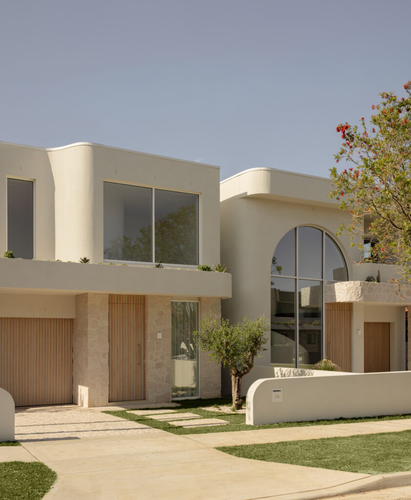 Curved rendered facade of Project Mars by Morrison Build with arched window and stone-clad portico.