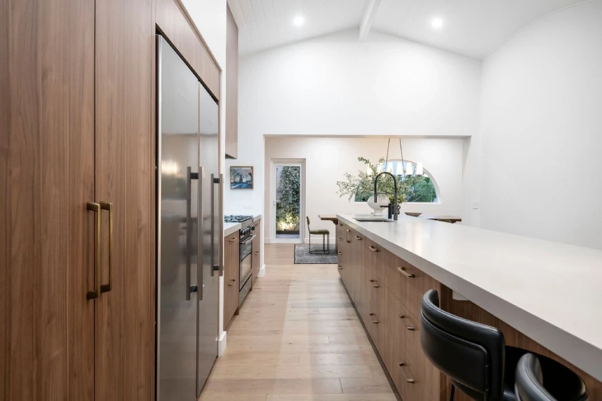 Warm contemporary kitchen with dark timber joinery and a Caesarstone<sup>®</sup> Raw Concrete benchtop